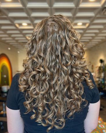 Client with long, defined blonde ringlet curls seen from behind
