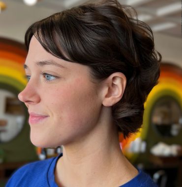 Client with a short dark pixie cut and side-swept bangs