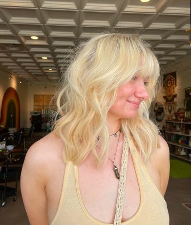 Client with bright platinum blonde layered hair and bangs