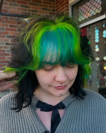 Client with black hair and vivid green and teal bangs