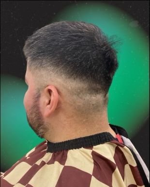 Client with a clean skin fade and textured top, seen from behind